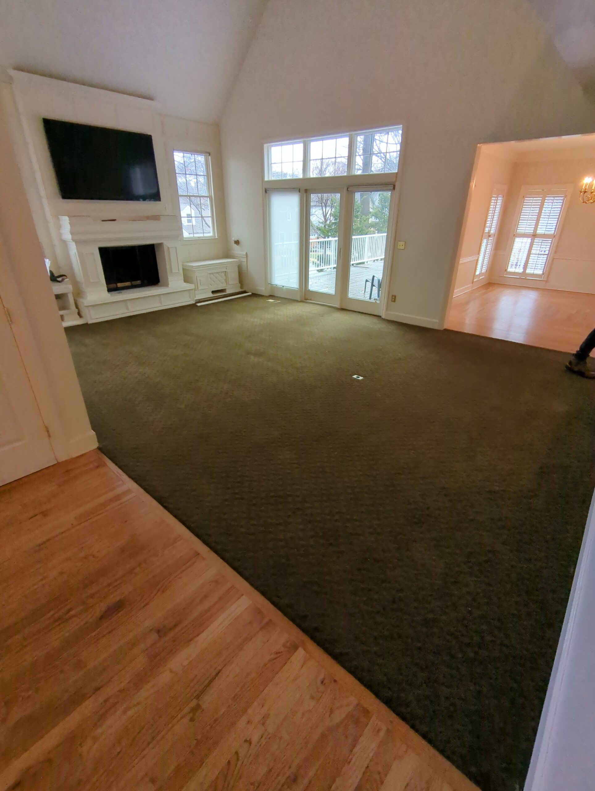 Old green carpet in Westwood KS living room before hardwood extension